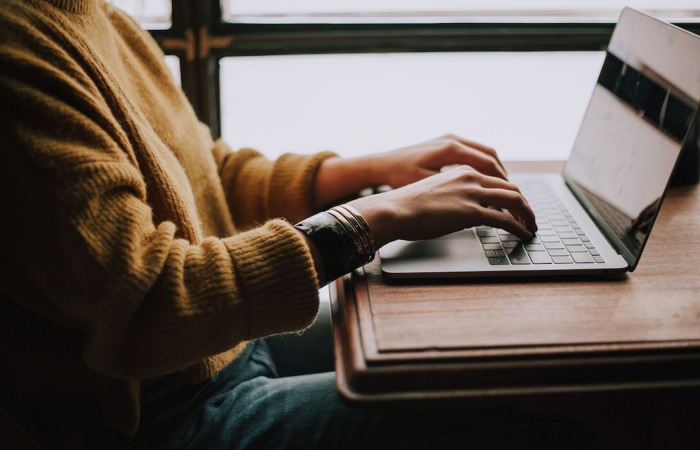 Person using laptop for relationship mapping and sitting on a desk